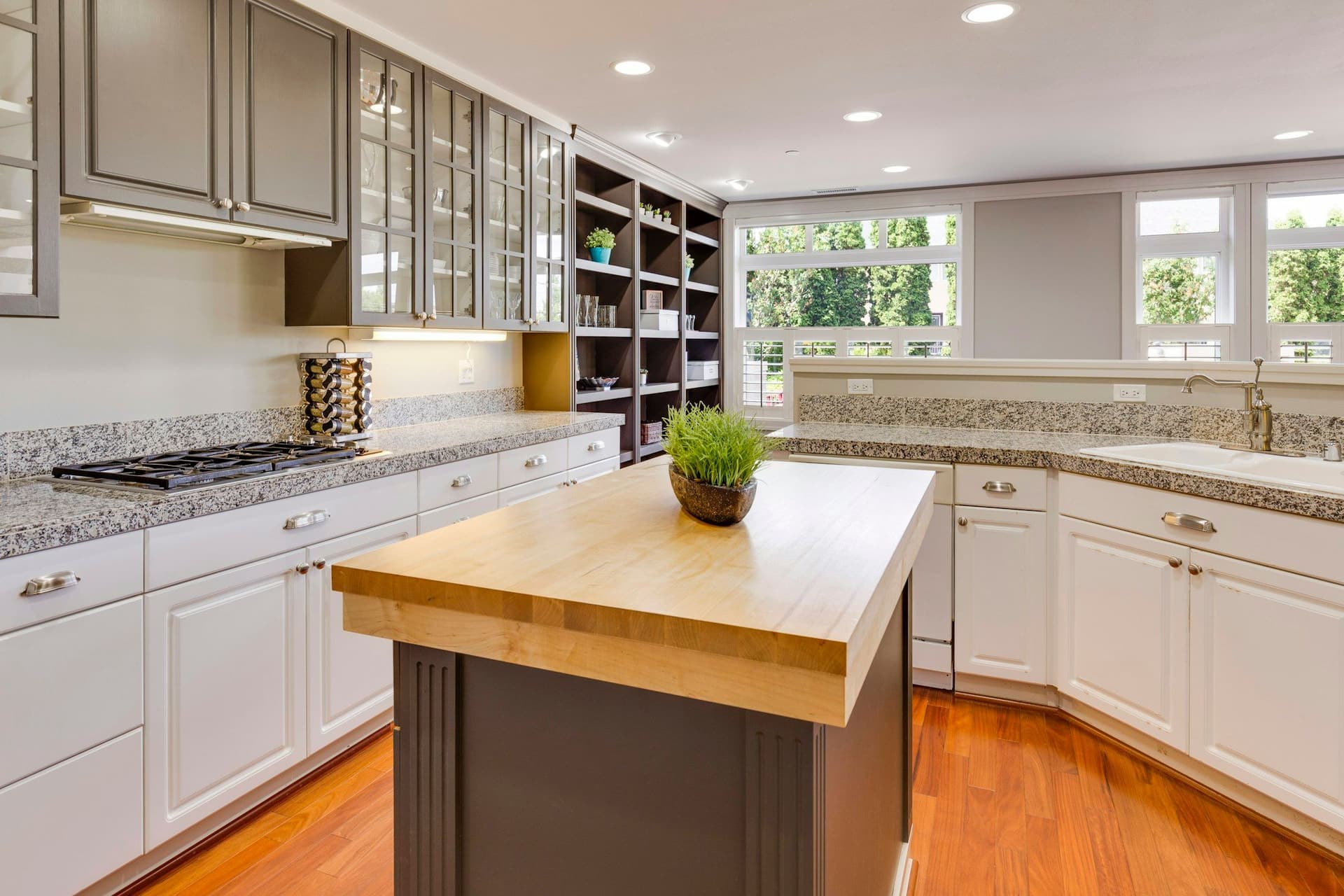 Kitchen with white raised-panel cabinets, granite countertops and a timber-topped island