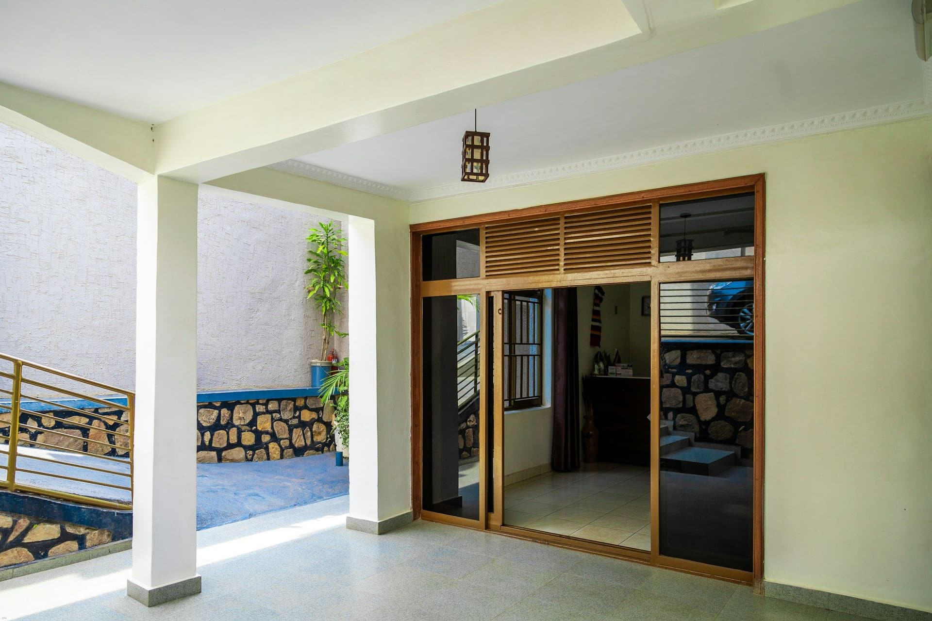 Timber-framed sliding glass doors set between white pillars on a covered patio